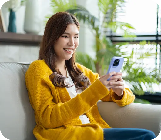 A smiling young woman holding a phone.